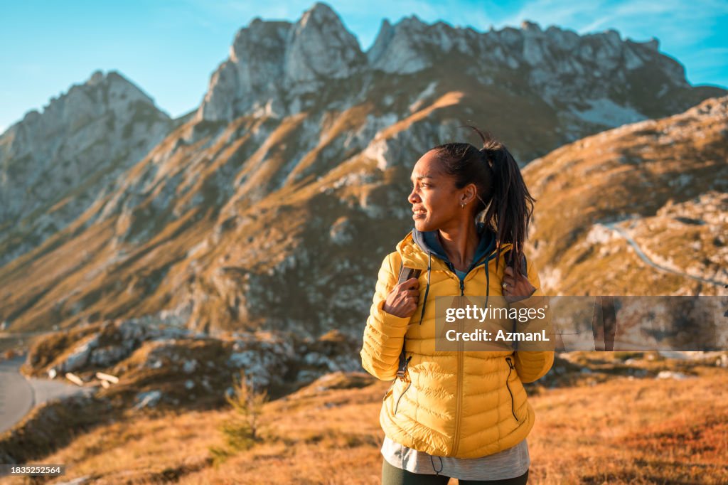 Mid Adult Hispanic Female in Yellow Jacket Hiking in Landscape