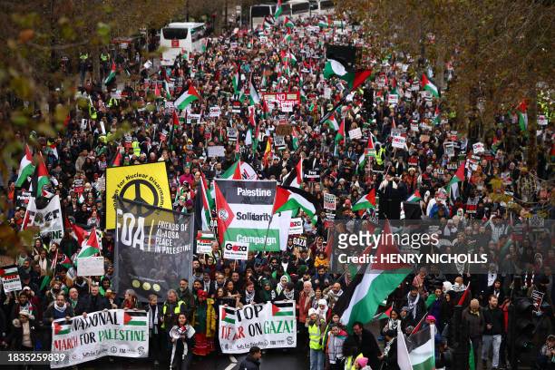 Pro-Palestinian activists and supporters wave flags and carry placards during a National March for Palestine in central London on December 9 calling...