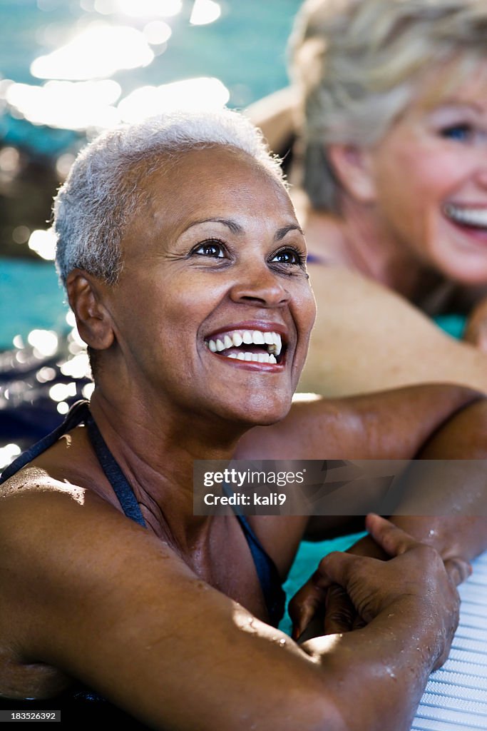 Beautiful African American senior woman in swimming pool laughin