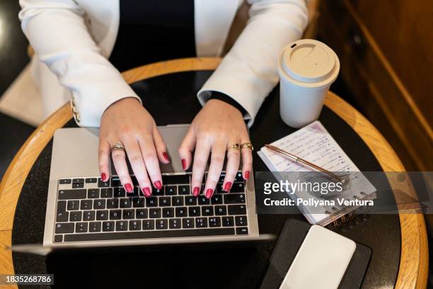 manos de mujer escribiendo en computadora portátil - esmalte de uñas rojo fotografías e imágenes de stock