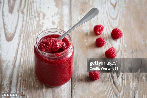 jar of raspberry jam on wooden surface - jam jar stock pictures, royalty-free photos & images