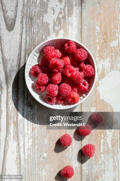 bowl of fresh raspberries on wooden surface - raspberry stock pictures, royalty-free photos & images