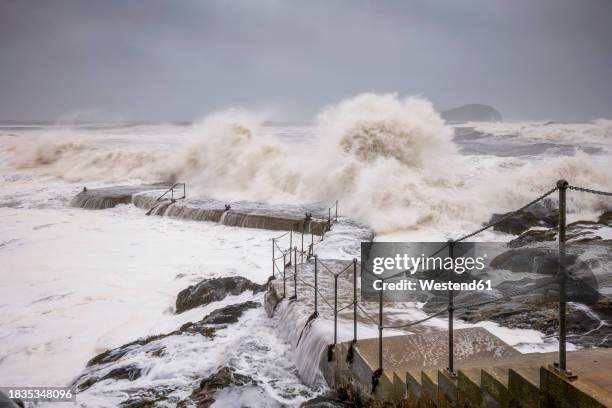uk, scotland, north berwick, waves splashing against coastal steps during storm babet - extreme weather wind stock pictures, royalty-free photos & images