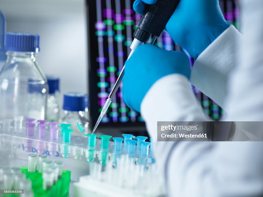 Scientist pipetting DNA sample into eppendorf tube for genetic testing