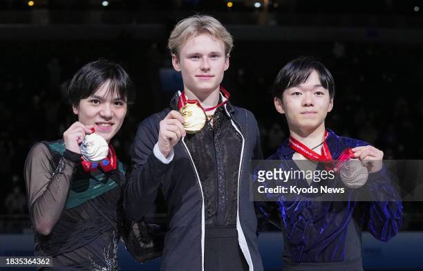Ilia Malinin of the United States poses after winning gold at the Grand Prix Final figure skating competition in Beijing on Dec. 9 alongside Shoma...