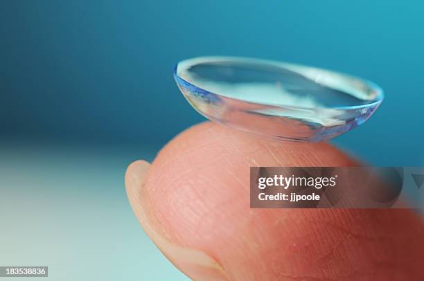 kontaktlinse auf blauem hintergrund - contacts stock-fotos und bilder