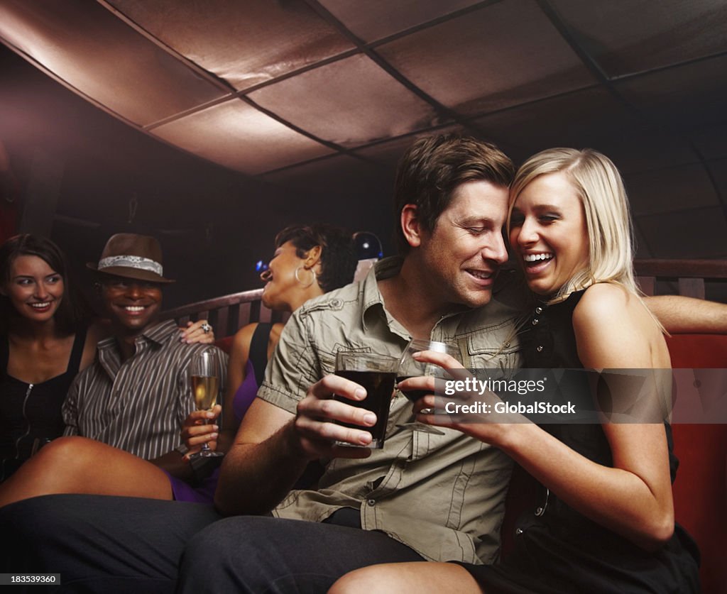 Romantic couple celebrating with friends at a night party