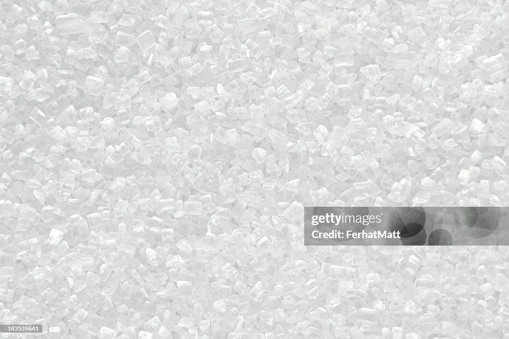 Piled up granules of white sugar shining