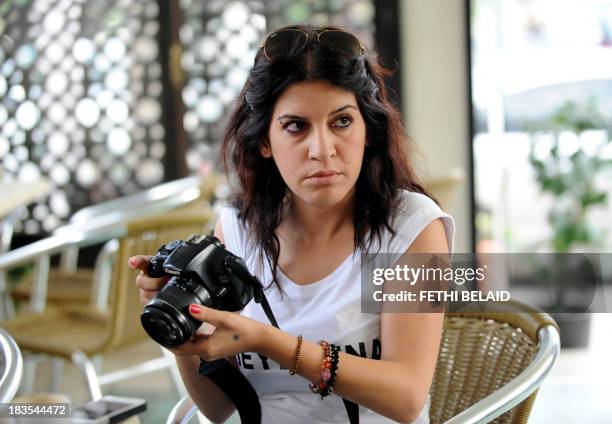 Human rights defender, internet-activist and blogger Lina Ben Mhenni, who was previosly nominated for the Nobel Peace prize, takes photos outside the...