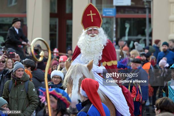 December 2023, Brandenburg, Potsdam: The historic Dutch Santa Claus figure Sinterklaas rides into Potsdam's Dutch Quarter to open the local Christmas...
