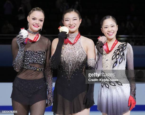 Kaori Sakamoto of Japan poses after winning gold at the Grand Prix Final figure skating competition in Beijing on Dec. 9 alongside Loena Hendrickx of...