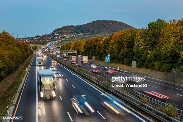 germany, baden-wurttemberg, aichelberg, traffic on bundesautobahn 8 at dusk - autobahn foto e immagini stock