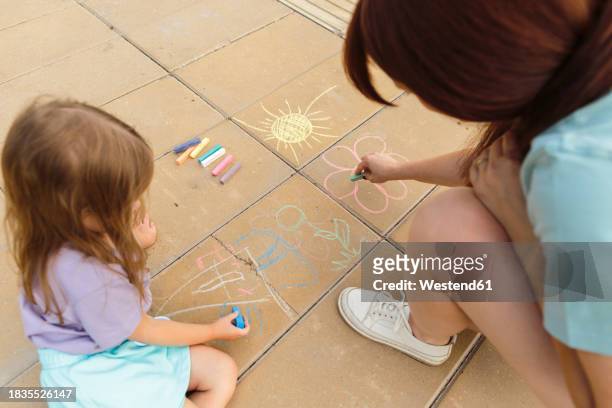 mother and daughter drawing on tiled floor at park - flooring stock pictures, royalty-free photos & images