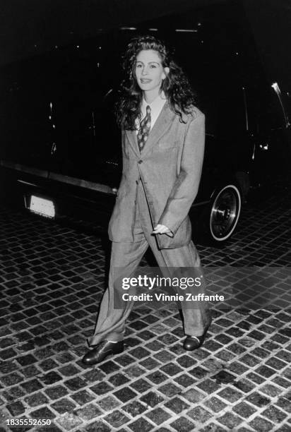 American actress Julia Roberts, wearing a grey trouser suit with a white shirt and patterned tie, attends the 47th Golden Globe Awards, held at the...