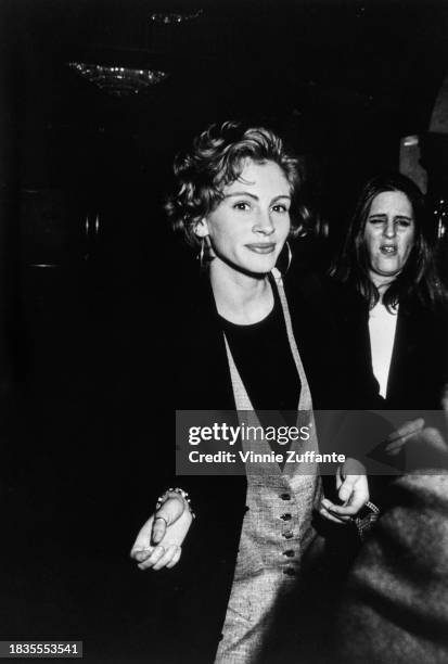 American actress Julia Roberts, wearing a dark crew neck top with hoop earrings, attends the NATO/ShoWest '91 convention, held at Bally's Hotel &...