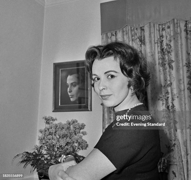 Actress Claire Bloom posing in front of a photographic portrait of herself on a wall, February 11th 1958.