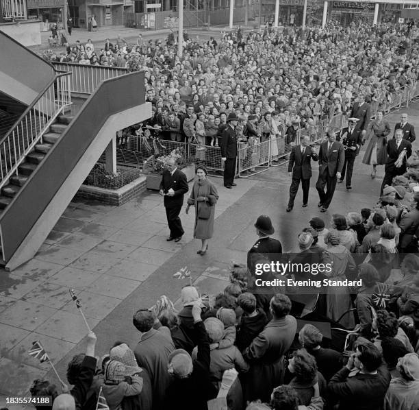 Queen Elizabeth II is greeted by crowds during a visit to Harlow, Essex, October 30th 1957. Prince Philip can be seen behind the Queen.