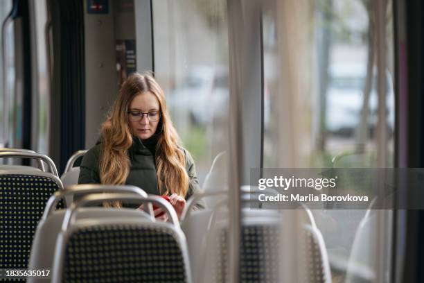 portrait of woman using phone in public transport. space for text. - trip photos et images de collection