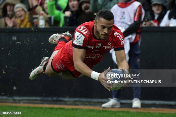Toulouse's French wing Matthis Lebel dives over the line to score Toulouse's first try during the European Champions Cup first round Pool 2 rugby...