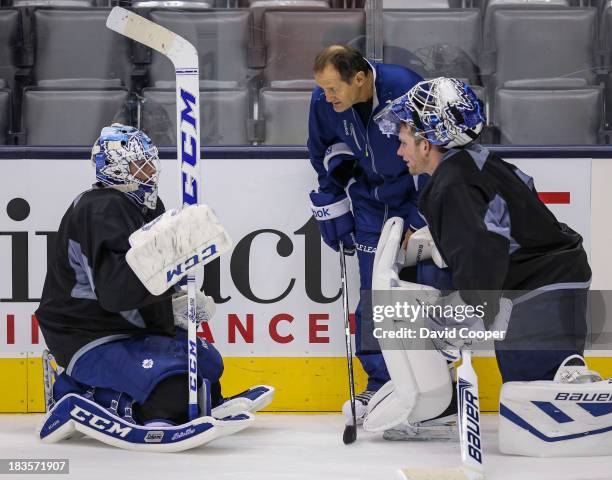 Toronto Maple Leafs goalie Jonathan Bernier , Goaltending coach Piero Greco, and goalie James Reimer talks near the side boards during practice at...