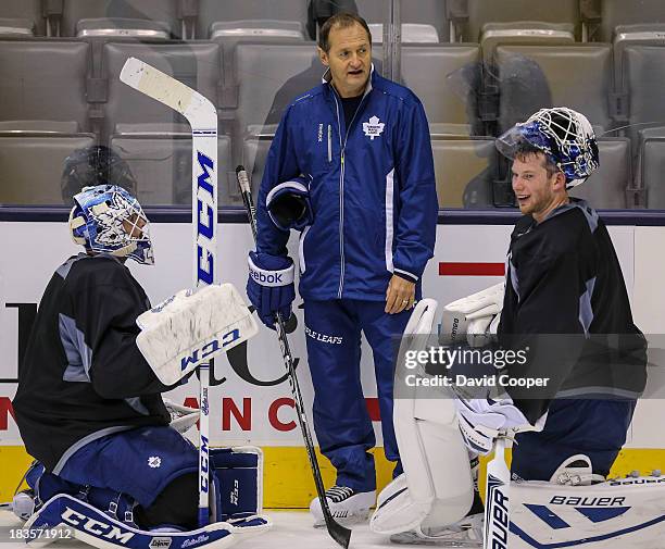 Toronto Maple Leafs goalie Jonathan Bernier , Goaltending coach Piero Greco, and goalie James Reimer talks near the side boards during practice at...