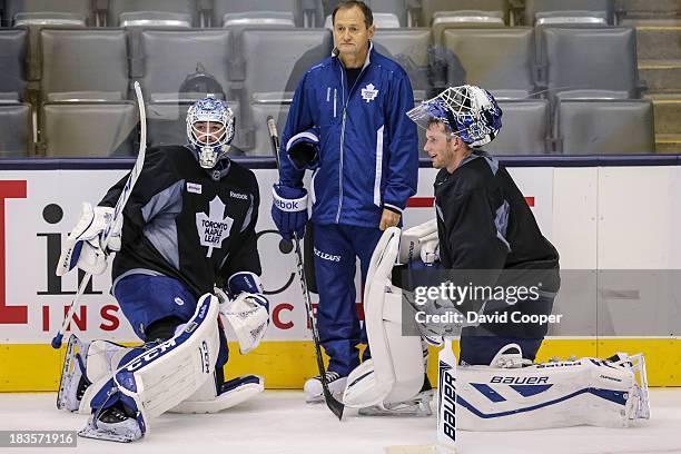 Toronto Maple Leafs goalie Jonathan Bernier , Goaltending coach Piero Greco, and goalie James Reimer talks near the side boards during practice at...