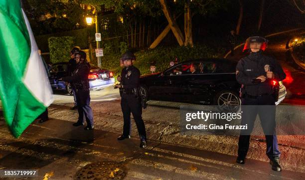 Los Angeles police officers in tactical gear maintain a perimeter to keep members of the Palestinian Youth Movement from advancing during a protest...