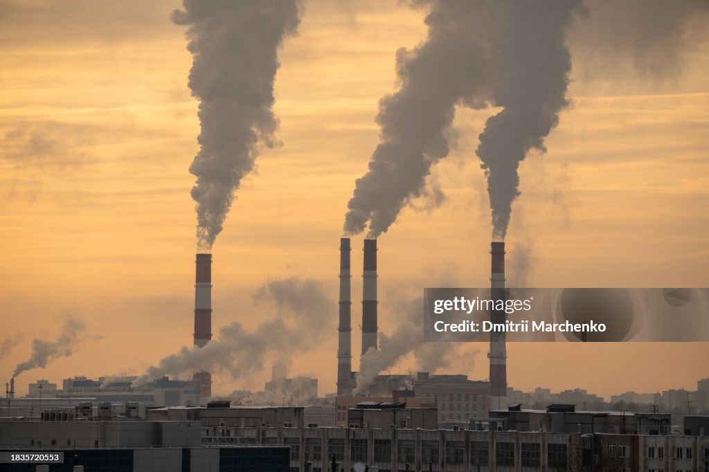 Smokestack pipes emitting co2 from coal thermal power plant into atmosphere. Industrial landscape.