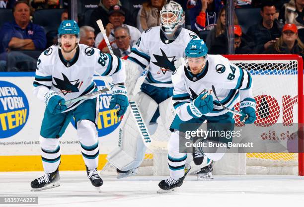 Nikita Okhotiuk and Jan Rutta of the San Jose Sharks defend against the New York Islanders at UBS Arena on December 05, 2023 in Elmont, New York.
