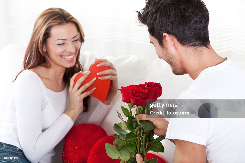 Casal Amoroso feliz com caixa de presente vermelha coração e rosas