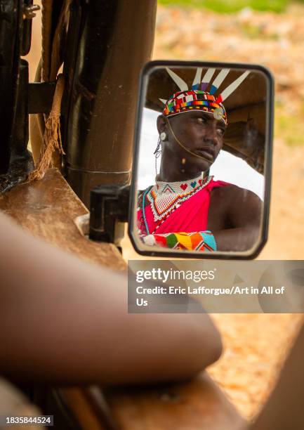 Portrait of a samburu moran in a car mirror, Samburu County, Samburu National Reserve, Kenya on November 25, 2023 in Samburu National Reserve, Kenya.