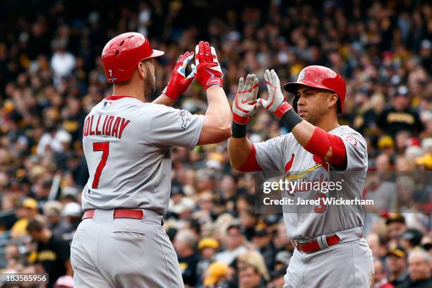 Matt Holliday of the St. Louis Cardinals celebrates scoring a two run home run with teammates Carlos Beltran against Charlie Morton of the Pittsburgh...