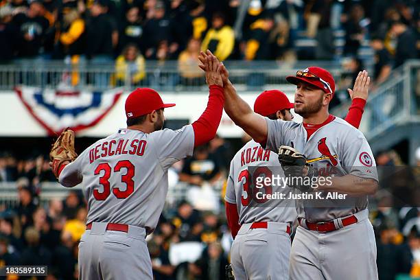 Daniel Descalso and Matt Holliday of the St. Louis Cardinals celebrate defeating the Pittsburgh Pirates in Game Four of the National League Division...