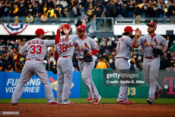 Daniel Descalso and Matt Holliday of the St. Louis Cardinals celebrate with their teammates after defeating the Pittsburgh Pirates in Game Four of...