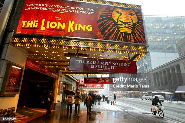 Pedestrians walk beneath a sign for the musical "The Lion King" March 6, 2003 in New York City. About 325 Broadway theater musicians are set to go on...