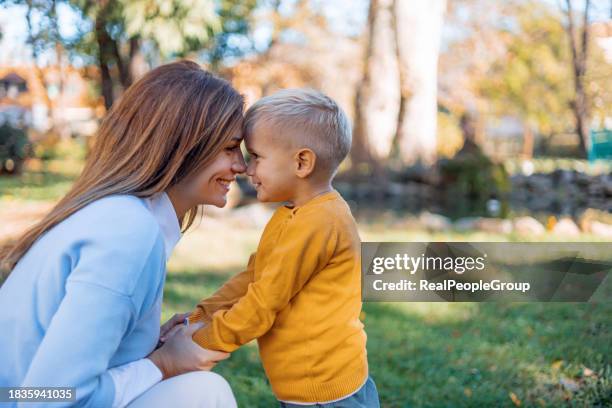 madre e figlio condividono una coccola all'aperto - nuzzling foto e immagini stock