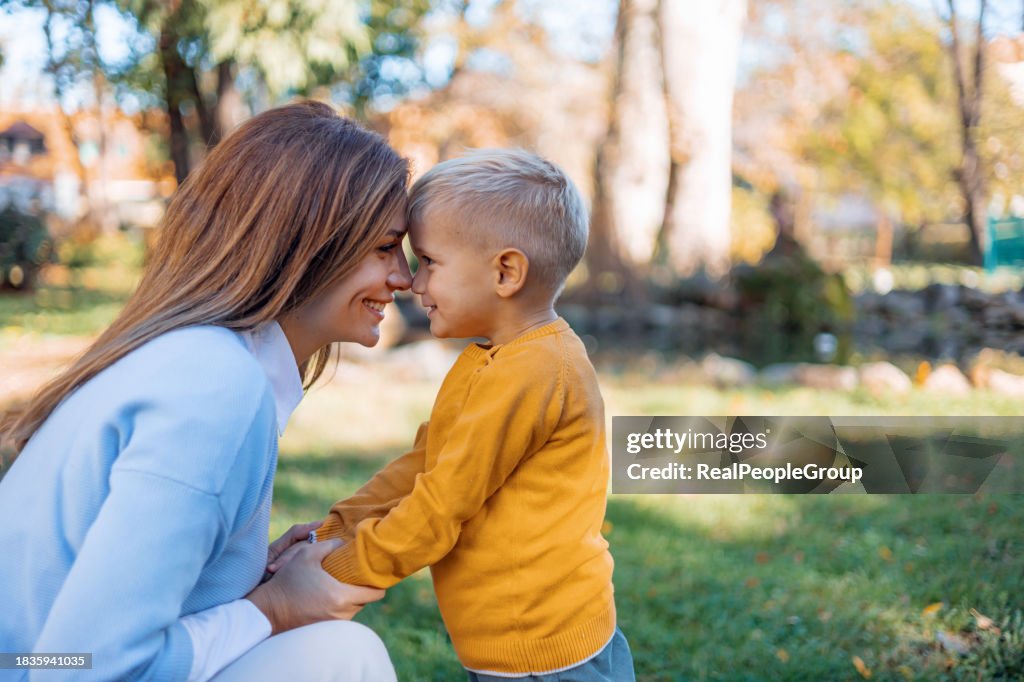 Mother and son share a cuddle outdoors