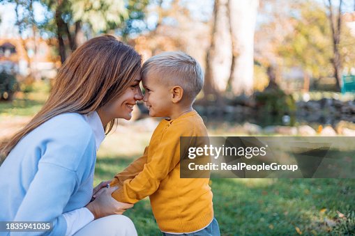 Mother and son share a cuddle outdoors Mother and son share a cuddle outdoors