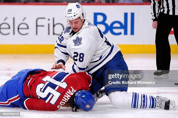 Colton Orr of the Toronto Maple Leafs gets up after George Parros of the Montreal Canadiens hit the ice face first while fighting during the NHL game...