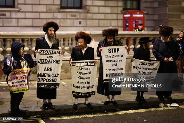 Members of the Ultra-Orthodox Jewish community hold placards as they take part in a National March for Palestine in central London on December 9...