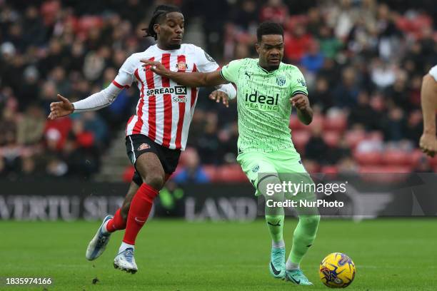 Grady Diangana of West Bromwich Albion is being chased by Pierre Ekwah of Sunderland during the Sky Bet Championship match between Sunderland and...