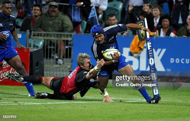 Sam Tuitupou of the Blues pushes off Justin Marshall of the Crusaders during the Super 12 match between the Auckland Blues and the Canterbury...
