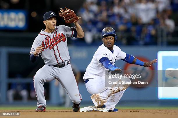 Hanley Ramirez of the Los Angeles Dodgers and Andrelton Simmons of the Atlanta Braves react after Ramirez steals second base in the first inning in...