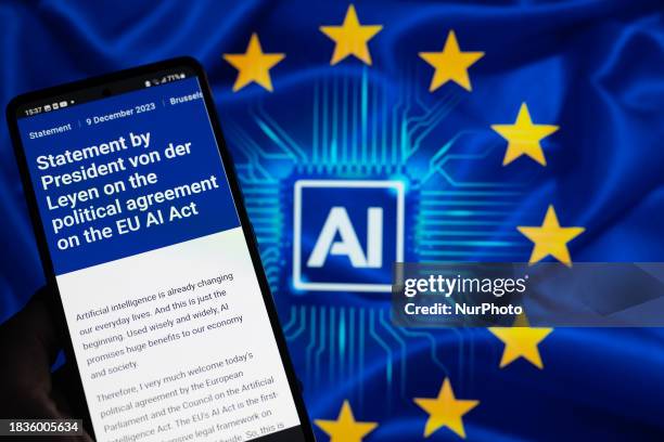 The statement from the European Commission is being displayed on a smartphone with AI and EU stars in the background, in this photo illustration. EU...