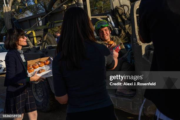 Volunteers hand sufganiot and hanukkiahs the day before Hanukkah begins near the Gaza border on December 06, 2023 in Southern Israel. Israel and...