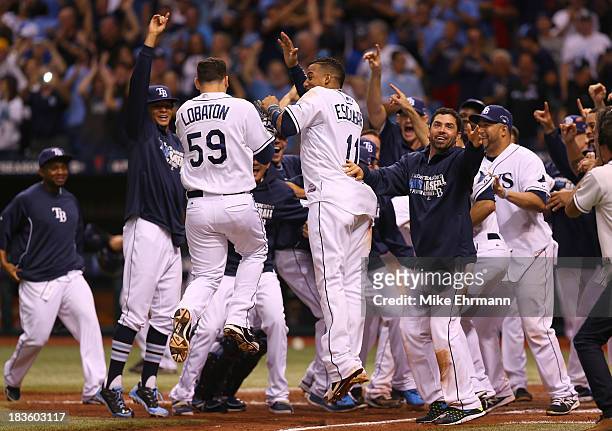 Jose Lobaton of the Tampa Bay Rays is greeted at home by his teammates after hitting a walk off home run in the bottom of the ninth to defeat the...