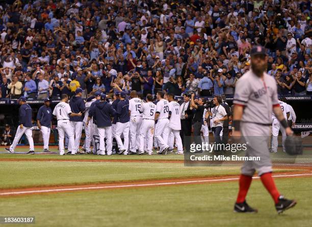 The Tampa Bay Rays celebrate after Jose Lobaton hits a walk off home run in the bottom of the ninth as Mike Napoli of the Boston Red Sox walks off...