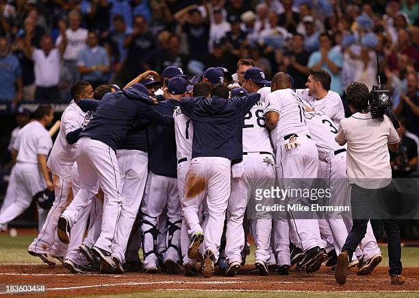 The Tampa Bay Rays celebrate after a walk off home run by Jose Lobaton in the bottom of the ninth inning to defeat the Boston Red Sox during Game...