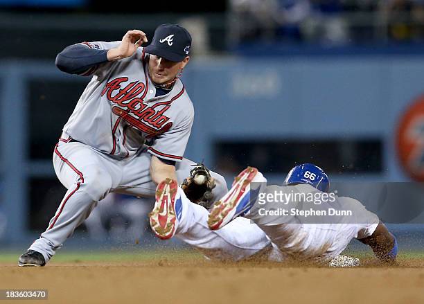 Elliot Johnson of the Atlanta Braves tags out Yasiel Puig of the Los Angeles Dodgers as Puig is caught stealing in the fourth inning in Game Four of...