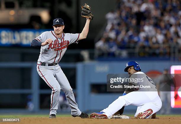 Elliot Johnson of the Atlanta Braves tags out Yasiel Puig of the Los Angeles Dodgers as Puig is caught stealing in the fourth inning in Game Four of...